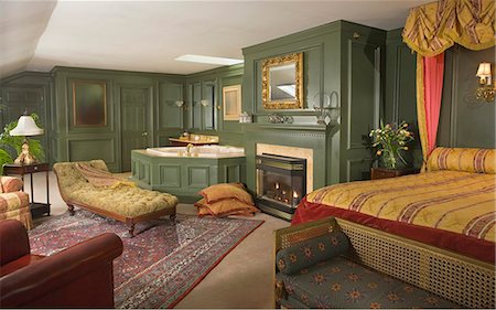 fireplace autumn - Green bedroom with double bed, leather armchair and chaise longue. Stock Photo - Rights-Managed, Code: 872-08914851