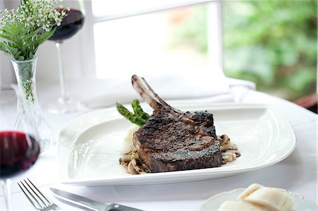 steak knife - Bone in rib eye steak served on white oval plate, Club Continental, Orange Park, FL. Photographie de stock - Rights-Managed, Code: 872-08915055