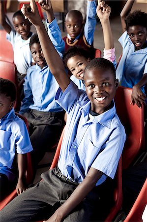 simsearch:873-06675608,k - African school pupils smiling at camera with their hands in the air Fotografie stock - Rights-Managed, Codice: 873-06675250