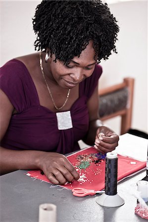 simsearch:873-06675608,k - Young African woman doing beadwork at a desk Fotografie stock - Rights-Managed, Codice: 873-06675601