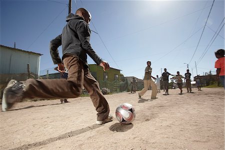 sudafricano (lugares y cosas) - Boy kicking a soccer ball in a dusty street, Vredenburg, Western Cape Province Foto de stock - Con derechos protegidos, Código: 873-07156752
