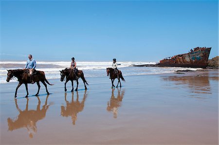 Horse back rides on the beach with the Jacaranda shipwreck in the background Foto de stock - Con derechos protegidos, Código: 873-07156825